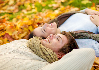 Image showing close up of smiling couple lying in autumn park