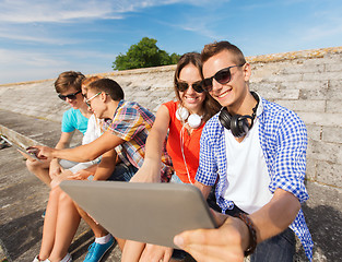 Image showing group of smiling friends with tablet pc outdoors