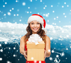 Image showing smiling woman in red dress with gift box