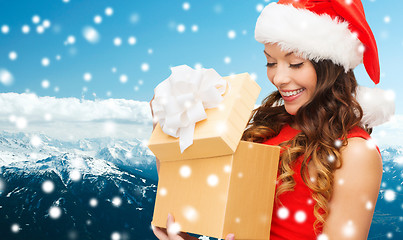 Image showing smiling woman in red dress with gift box