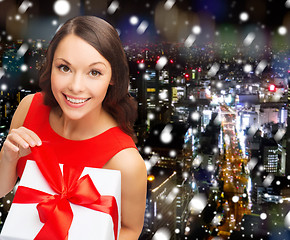 Image showing smiling woman in red dress with gift boxes