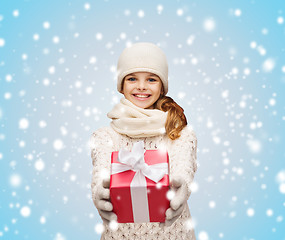 Image showing girl in hat, muffler and gloves with gift box