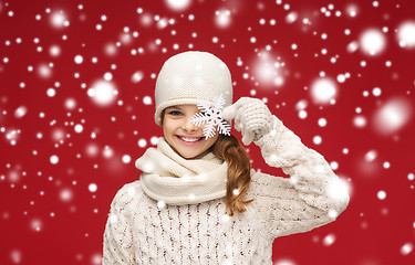 Image showing smiling girl in winter clothes with big snowflake