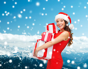 Image showing smiling woman in red dress with gift box