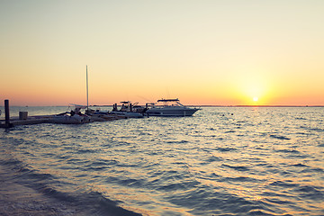 Image showing boats moored to pier at sundown