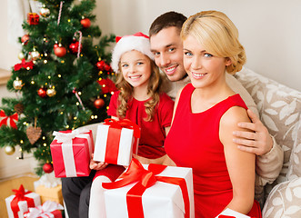 Image showing smiling family holding many gift boxes