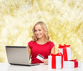 Image showing smiling woman with credit card and laptop