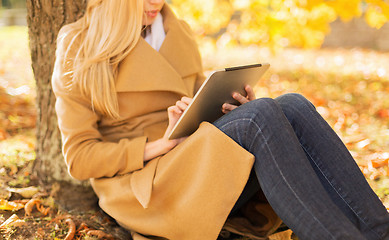 Image showing young woman with tablet pc in autumn park