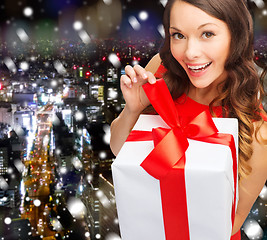 Image showing smiling woman in red dress with gift boxes