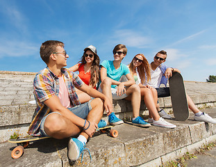 Image showing group of smiling friends sitting on city street