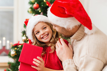 Image showing smiling father and daughter opening gift box