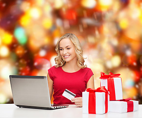 Image showing smiling woman with credit card and laptop