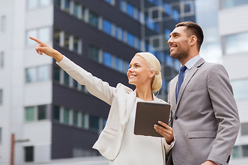 Image showing smiling businessmen with tablet pc outdoors