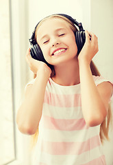 Image showing little girl with headphones at home