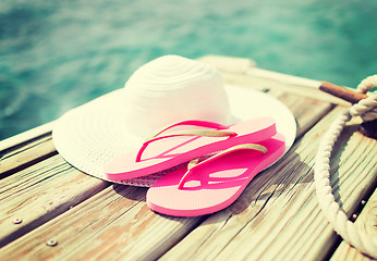 Image showing close up of hat and slippers at seaside