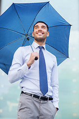 Image showing young smiling businessman with umbrella outdoors