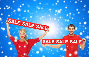 Image showing smiling man and woman with red sale signs