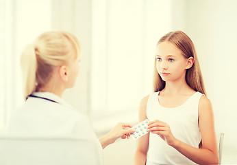 Image showing doctor giving tablets to child in hospital