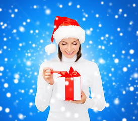 Image showing smiling woman in santa helper hat with gift box