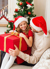 Image showing smiling father and daughter opening gift box