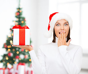 Image showing smiling woman in santa helper hat with gift box