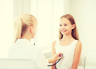 Image showing doctor with stethoscope listening to the patient