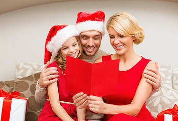 Image showing smiling family reading postcard