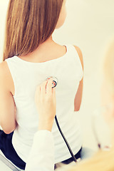 Image showing doctor with stethoscope listening to child back