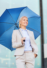 Image showing young smiling businesswoman with umbrella outdoors