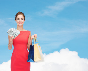 Image showing smiling elegant woman in dress with shopping bags