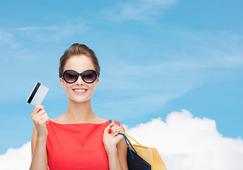 Image showing smiling woman with shopping bags and plastic card