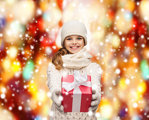 Image showing girl in hat, muffler and gloves with gift box