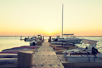 Image showing boats moored to pier at sundown