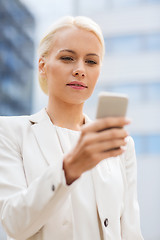 Image showing serious businesswoman with smartphone outdoors