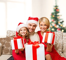 Image showing smiling family giving many gift boxes