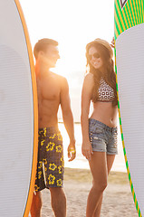 Image showing smiling couple in sunglasses with surfs on beach