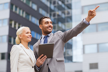 Image showing smiling businessmen with tablet pc outdoors