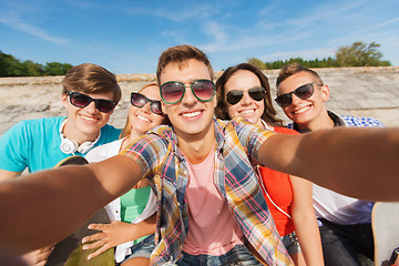 Image showing group of smiling friends making selfie outdoors