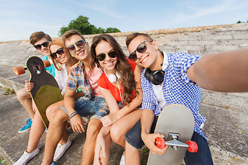 Image showing group of smiling friends with smartphone outdoors