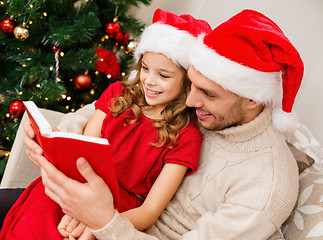 Image showing smiling father and daughter reading book