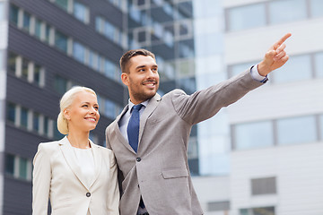 Image showing smiling businessmen standing over office building