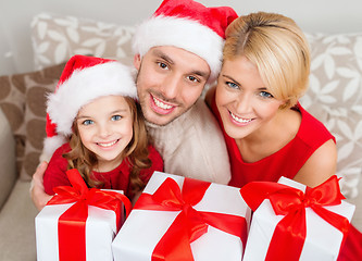 Image showing smiling family holding many gift boxes