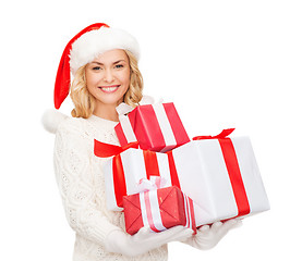 Image showing woman in santa helper hat with many gift boxes