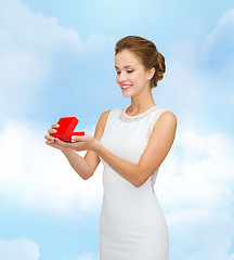 Image showing smiling woman holding red gift box