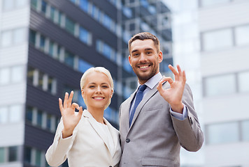 Image showing smiling businessmen standing over office building