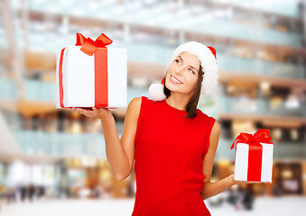 Image showing smiling woman in red dress with gift box