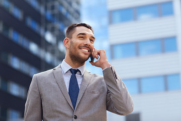 Image showing smiling businessman with smartphone outdoors
