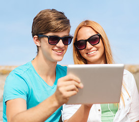 Image showing group of smiling friends with tablet pc outdoors