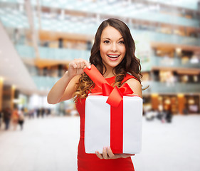 Image showing smiling woman in red dress with gift boxes