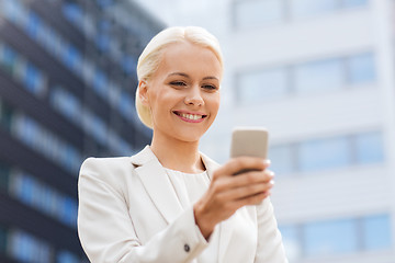 Image showing smiling businesswoman with smartphone outdoors